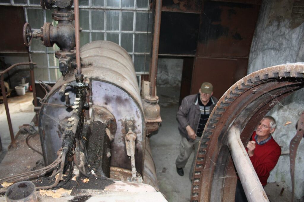 Vrijwilligers bekijken de stoommachine in de hal in Mognéville