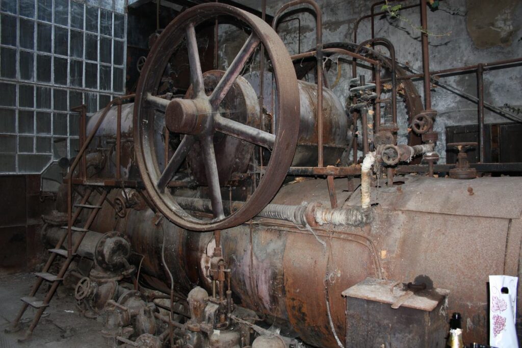 De stoommachine met het grote vliegwiel in de houtzagerij