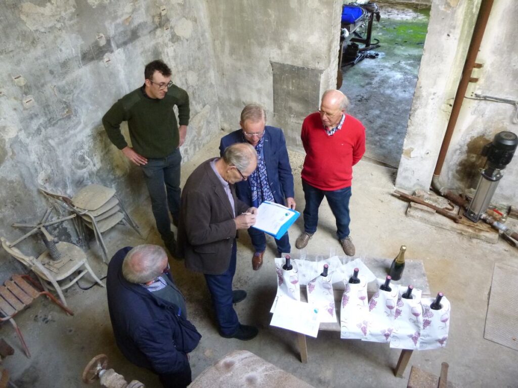 Mannen rond een tafel met papieren in de machinehal in Mognéville
