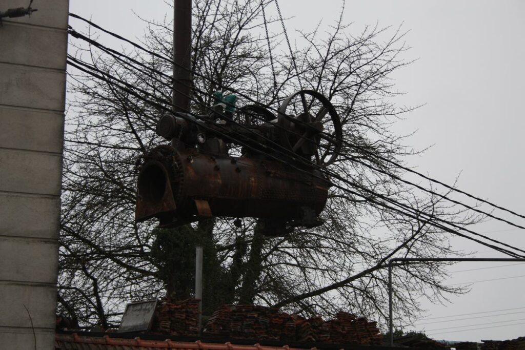 De stoommachine hangt aan de kraan, boven bomen en kabels
