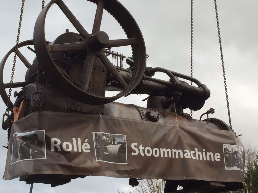 De stoommachine met een spandoek van Rollé aan de kraan